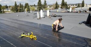 Silverback Torch On Systems Ltd. team removing gravel from a built-up commercial flat roof as part of replacement project